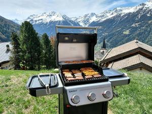 a grill with food on it with mountains in the background at Chalet Bisse Neuf in Saint-Luc