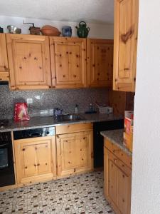 a kitchen with wooden cabinets and a sink at Chalet Bisse Neuf in Saint-Luc +22 photos