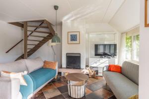 a living room with a couch and a fireplace at Cozy Waterfront Getaway for a Perfect Holiday in Langweer