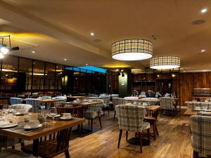 a restaurant with wooden tables and chairs and lights at Le Mallet, Courmayeur, Alpine Homesuite in Courmayeur