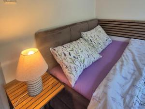 a bed with a lamp on a table next to it at DORMAR II Apartament in Wałbrzych