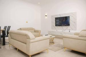 a living room with two chairs and a tv at Chamacohouse in Cotonou