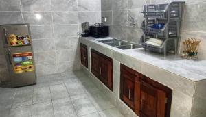 a kitchen with a sink and a refrigerator at Chamacohouse in Cotonou
