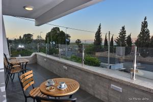 a table and chairs on a balcony with a view at מקום טוב באמצע במושבת כנרת in Kinneret