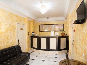 a lobby with a black leather couch and a bar at Taugul Hotel in Almaty