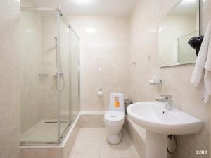 a bathroom with a toilet and a sink and a shower at Taugul Hotel in Almaty