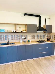 a kitchen with blue cabinets and a stove top oven at Cozy Dez Guest House with Dreamy Mountain Views in Margahovit