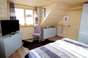 a bedroom with a bed and a tv in a room at Chalet Fuchsberg in Mauth