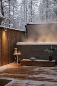 a hot tub on a wooden deck with a table at Ainur Villas in Saariselka