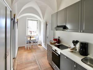 a kitchen with gray cabinets and a table in it at Schlossgut Franken in Redwitz an der Rodach
