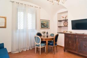 a dining room with a table and chairs and a television at I Vacanzieri in Catania