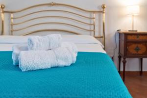 a pile of towels sitting on top of a bed at I Vacanzieri in Catania