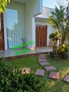 a garden with stepping stones in front of a house at Quarto suíte privativo acesso independente in Genuino Sampaio