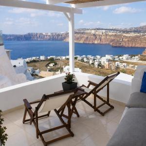 a balcony with two chairs and a table with a view at SantoCaves in Akrotiri