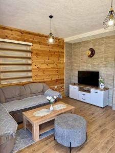 a living room with a couch and a coffee table at A&A Durmitor Apartments in Žabljak