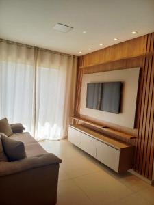 a living room with a couch and a flat screen tv at Novíssimo Altiplano 3 Quartos e Lazer Completo in João Pessoa