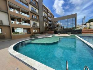 a large swimming pool in front of a building at Novíssimo Altiplano 3 Quartos e Lazer Completo in João Pessoa