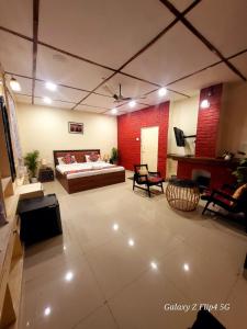 a large room with a bed and a couch at Sarovar Palace in Prayagraj