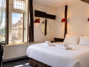a bedroom with a large white bed and a window at Hôtel Les Trois Luppars in Arras