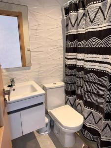 a bathroom with a black and white shower curtain and a toilet at Nador hola corniche in Nador