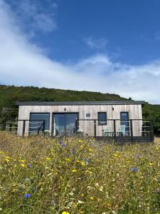 a house on a hill with flowers in front of it at Tiny Mara in Uig