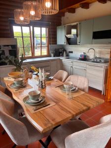 eine Küche mit einem Holztisch und Stühlen drumherum. in der Unterkunft Westerwald Lodge in Stahlhofen