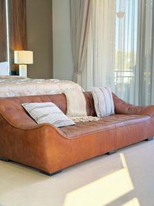 a brown leather couch sitting in a living room at Roses Villa at Elysium Home in Dodoma +36 photos