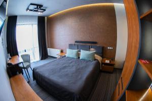 ein Schlafzimmer mit einem großen Bett und einer Holzwand in der Unterkunft MOJO HALL Hotel in Luzk + 109 Fotos