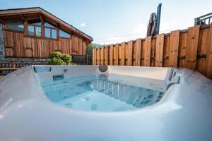 a hot tub in a backyard with a wooden fence at Chalet Namapa in Saint-Martin-de-Belleville