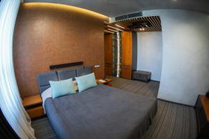 ein Schlafzimmer mit einem großen Bett und blauen Kissen in der Unterkunft MOJO HALL Hotel in Luzk