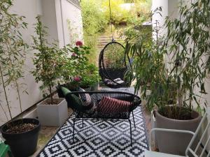 a patio with chairs and potted plants at Chez Ariel et Myrtille in Bruyères