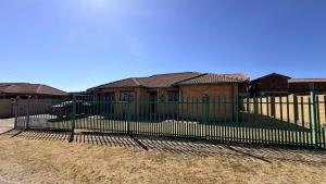 a black fence in front of a house at Trendy Tranquility in Secunda