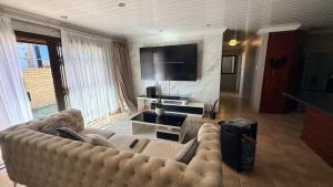 a living room with a couch and a flat screen tv at Trendy Tranquility in Secunda