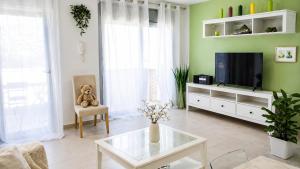 a living room with a teddy bear sitting in a chair at Spacious Duplex in Sitges with Sea Views, Terrace & Free Parking Area in Sitges