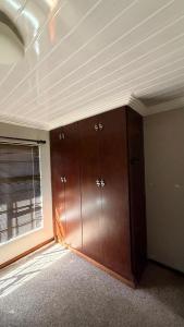 a room with wooden cabinets and a window at Trendy Tranquility in Secunda