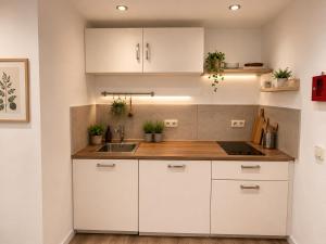 a kitchen with white cabinets and a sink at PaderQuartier2 in Paderborn