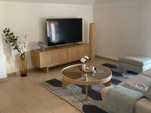 a living room with a tv and a couch and a table at Allegra am Niederrhein in Neukirchen-Vluyn