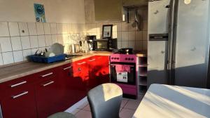 a kitchen with red cabinets and a pink stove at Luna Solis Stay Zimmer und Hostel nahe A1 in Heidenau
