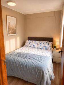 a bedroom with a bed with blue and white sheets at John D's Cabin Getaway in Derry Londonderry