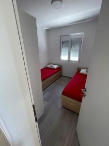 a small room with two beds and a window at Rujovic 