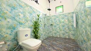 a bathroom with a toilet and a flower patterned wall at Blooming Hill Cabin Ella in Ella