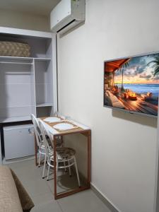 a room with a table and a tv on a wall at Quarto suíte privativo acesso independente in Genuino Sampaio
