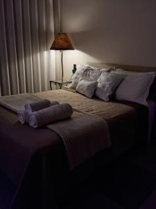 a bedroom with a bed with two towels on it at Quarto suíte privativo acesso independente in Genuino Sampaio