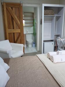 a bedroom with a bed and a sliding barn door at Quarto suíte privativo acesso independente in Genuino Sampaio +7 photos