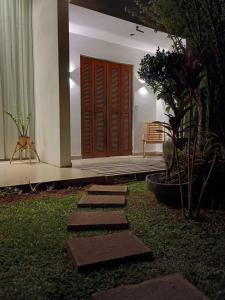 a garden with stepping stones in front of a house at Quarto suíte privativo acesso independente in Genuino Sampaio