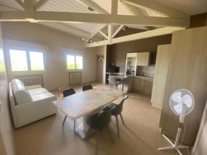 a living room with a table and chairs and a kitchen at Calme en vacances in Urrugne
