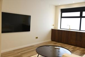 a living room with a table and a large flat screen tv at Amber Apartments in Jávea +80 photos