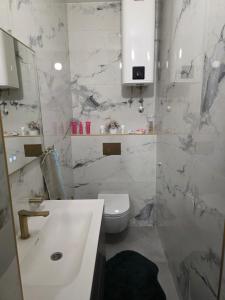 a white bathroom with a sink and a toilet at Riverside Residence Apartment in Travnik