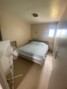 a small bedroom with a bed and a fan at Calme en vacances in Urrugne