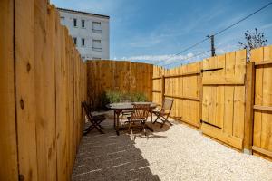 a patio with a table and chairs and a fence at Cristal Room in Rochefort
